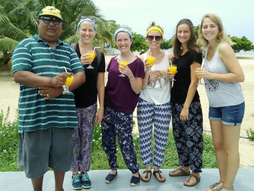 a group of people posing for a picture with drinks at Pasikudah Eco Village Hotel in Pasikuda