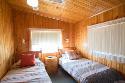 En eller flere senge i et værelse på Mundic Waterfront Cottages