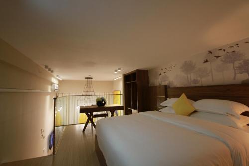 a bedroom with a large white bed and a desk at Yongke International Duplex Apartment in Guangzhou