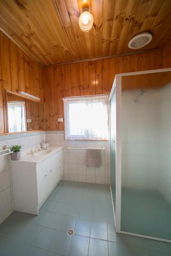 a bathroom with a shower and a sink and a tub at Mundic Waterfront Cottages in Renmark