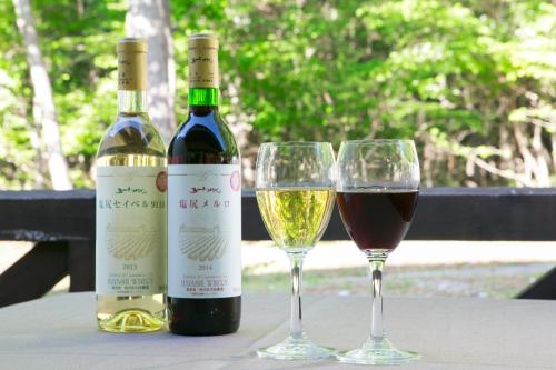 two bottles of wine and two glasses on a table at Sundance Resort Tateshina in Chino