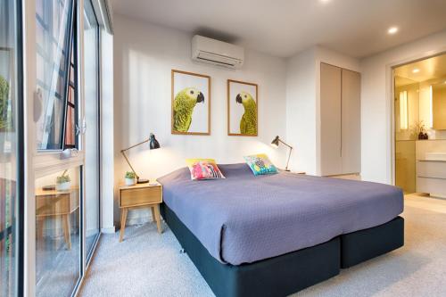 a bedroom with a bed and a table and two lamps at Orange Stay Townhouses in Melbourne