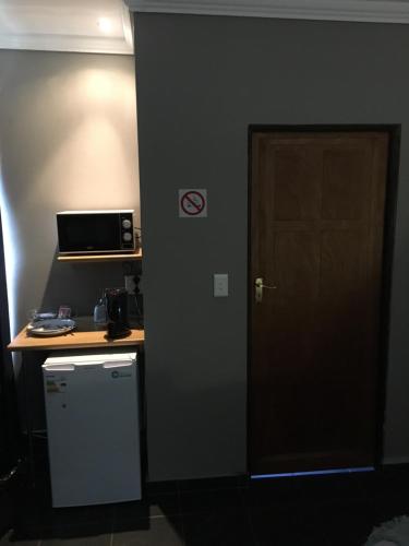 a room with a door and a table and a microwave at Bottom of Boden in Benoni