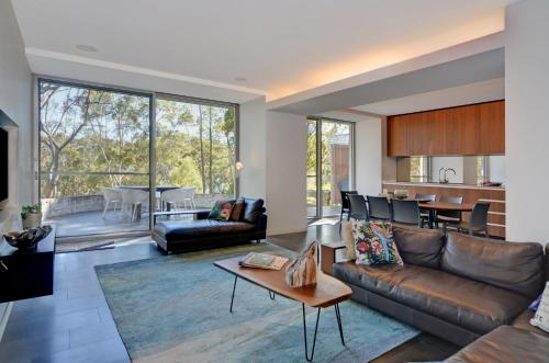 a living room with a couch and a table at Treehouse Jervis Bay in Vincentia