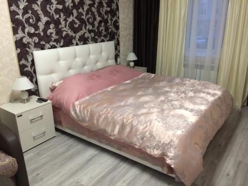 スーズダリにあるVspolye 19 Apartmentのベッドルーム1室(白いヘッドボード付きのベッド1台、ナイトスタンド付)
