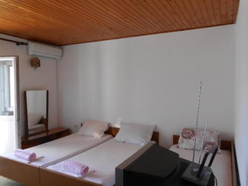 a bedroom with a bed with a tv on it at Apartment and Rooms Novka in Kotor