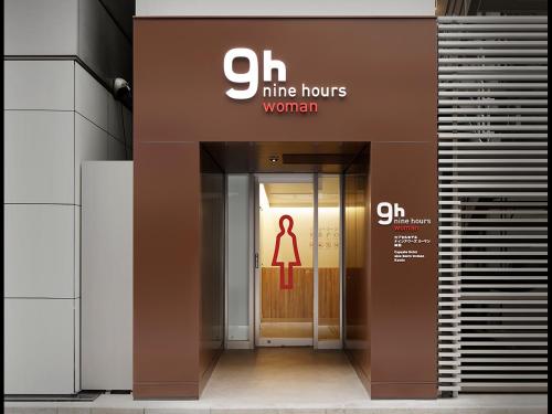 un edificio con un cartel que lee g chi horas de línea mujeres en 9h nine hours woman Kanda, en Tokio