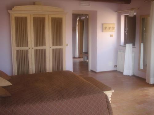 a bedroom with a bed and a closet in it at Villa Collio Relais in San Severino Marche