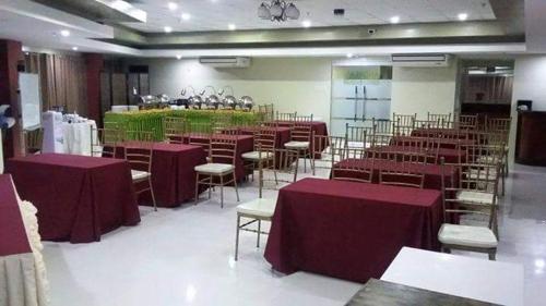 a room filled with tables and chairs with purple table cloth at Hotel Rodolfo in Tacloban
