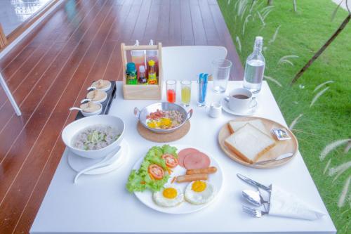a table with a plate of breakfast food on it at West View Villa in Kanchanaburi