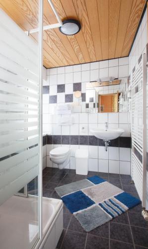 a bathroom with a sink and a toilet and a tub at Gasthaus zur Linde in Braunweiler