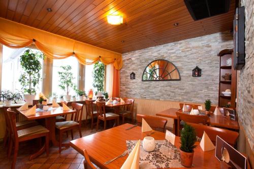 a restaurant with wooden tables and chairs and windows at Gasthaus zur Linde in Braunweiler