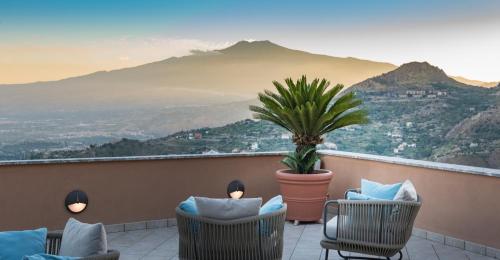 a balcony with chairs and a view of a mountain at Villa Le Terrazze Charming Rooms in Taormina