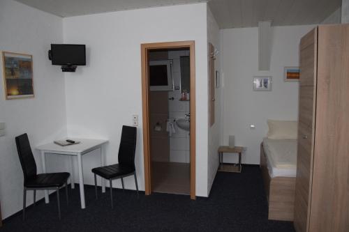 a small room with a room with a bed and a bathroom at Hotel Gästehaus Sonne in Sinsheim