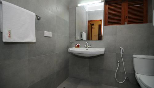 a bathroom with a sink and a toilet at Hotel Shanelo in Negombo