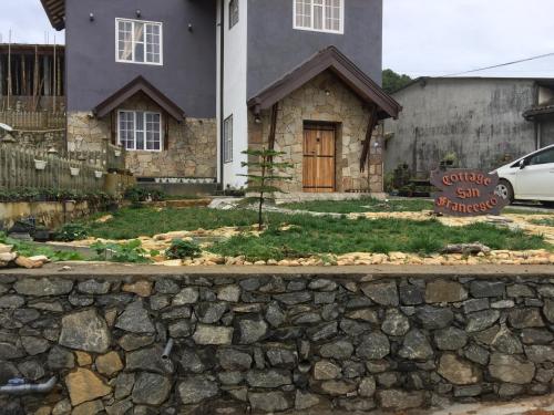 a stone wall in front of a house at Cottage San Francesco in Nuwara Eliya