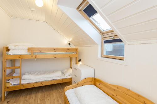 Sjøsanden Ferietun في ماندال: غرفة نوم مع أسرة بطابقين في منزل صغير