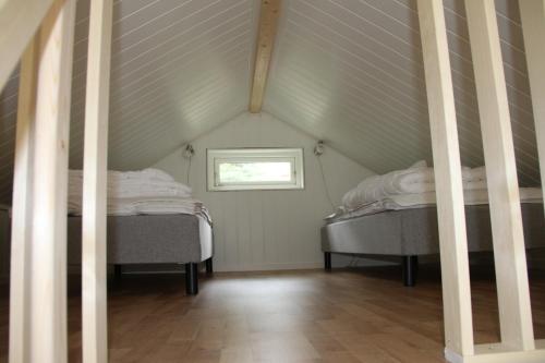 two beds in a attic room with a window at Evedals Camping Växjö in Växjö