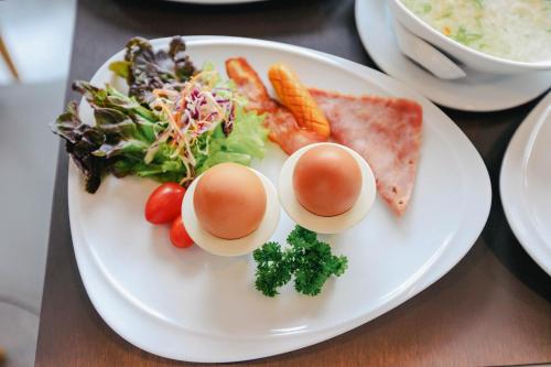 a plate of eggs and vegetables on a table at Wealth Boutique Hotel Chiang Mai in Chiang Mai
