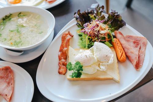 a plate of food with a salad and a bowl of soup at Wealth Boutique Hotel Chiang Mai in Chiang Mai