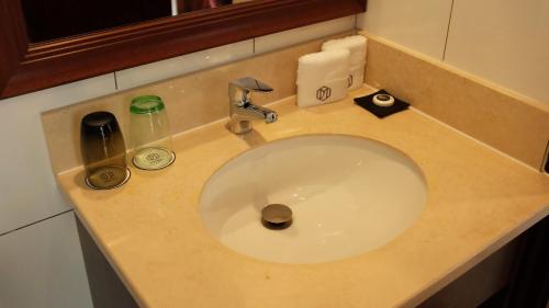 a bathroom counter with a sink with a soap dispenser at Dmall Hotel in Kigali