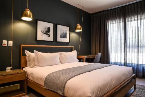 een slaapkamer met een groot bed en een raam bij The Residency Sandhurst in Johannesburg