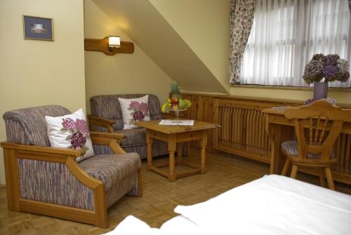 - une chambre avec deux chaises, une table et un lit dans l'établissement Gasthof Manner, à Perg