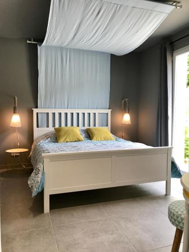 - une chambre avec un lit blanc et 2 oreillers jaunes dans l'établissement Pays des Senteurs, à Saint-Ferréol-Trente-Pas