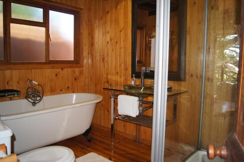 a bathroom with a tub and a glass shower at House 37 Nkululeko in Sodwana Bay Lodge - no loadshedding in Sodwana Bay