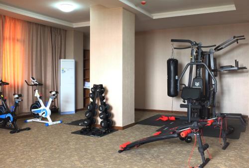 un gimnasio con varios equipos de ejercicio en una habitación de hotel en Dmall Hotel, en Kigali