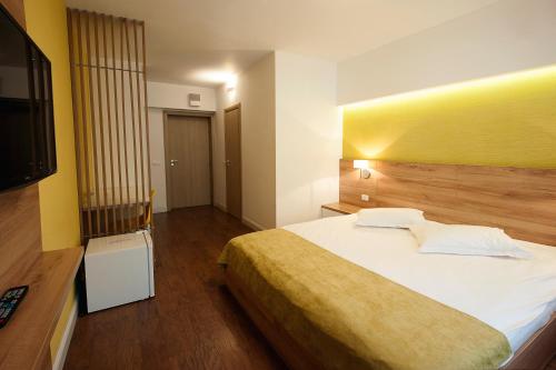 a bedroom with a large bed and a television at Hotel Ceramica in Iaşi
