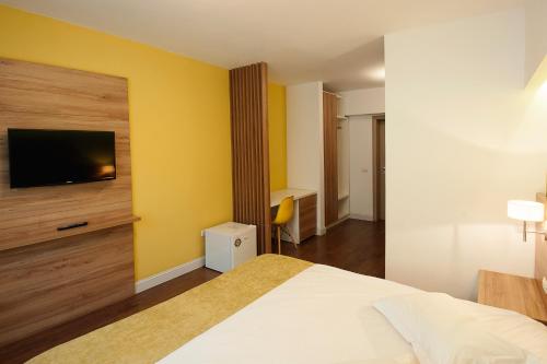 a hotel room with a bed and a flat screen tv at Hotel Ceramica in Iaşi