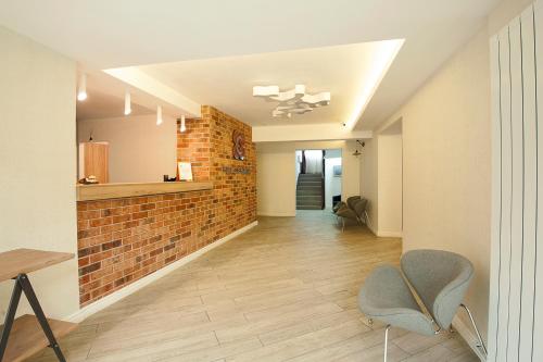 a living room with a brick wall and a chair at Hotel Ceramica in Iaşi