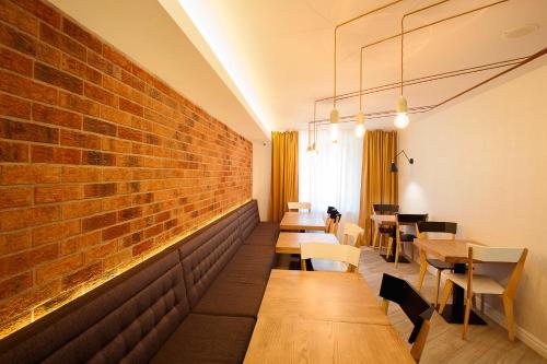 a restaurant with wooden tables and a brick wall at Hotel Ceramica in Iaşi