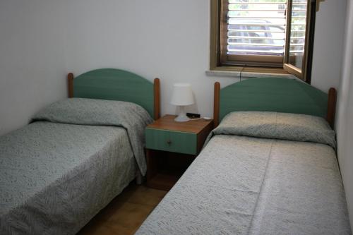 a bedroom with two twin beds and a window at Residence Il Turistico in Zambrone