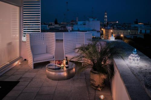 d'une terrasse avec une chaise et une table sur un balcon. dans l'établissement B&B Il Palazzotto Luxury Suites, à Lecce