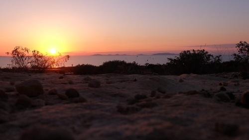 a sunset on a beach with the sun in the sky at Roccabianca in Sorso