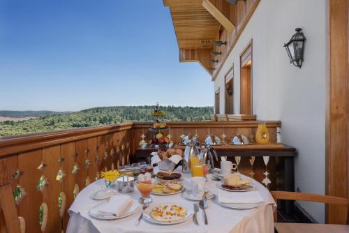 a table with plates of food on a balcony at Michlifen Resort & Golf in Ifrane