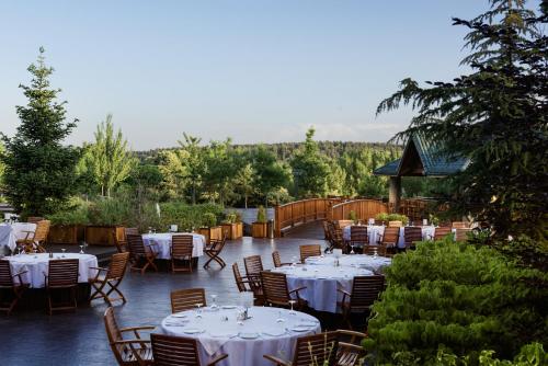 a restaurant with white tables and chairs on a patio at Michlifen Resort & Golf in Ifrane