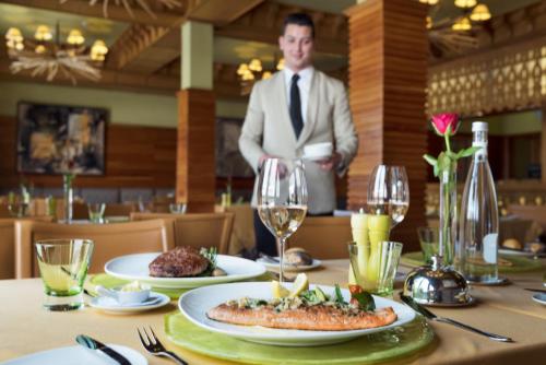 a man standing behind a table with a plate of food at Michlifen Resort & Golf in Ifrane