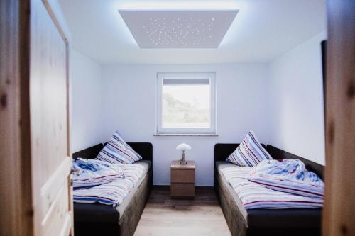 a small room with two beds and a window at Landhaus Boldevitz in Boldevitz