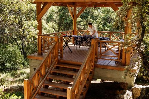 a man sitting at a table on a wooden deck at Michlifen Resort & Golf in Ifrane