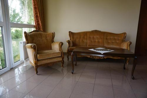 a living room with two chairs and a coffee table at Hotel Copernicus in Lubawa