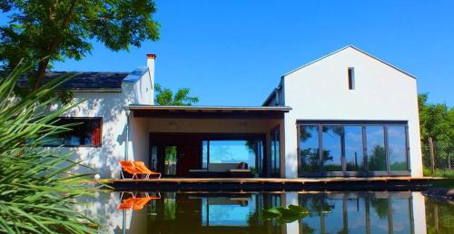 a house with a swimming pool in front of a house at Héthatár Wellness Vendégház - Vörösbegy in Dabas