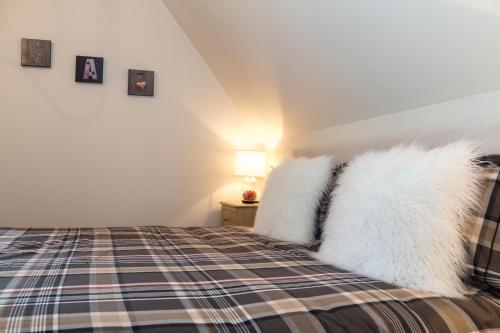 a bedroom with a bed with white fur pillows at Les Chambres Chez Christine in Ottrott