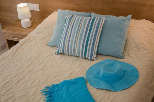a bed with blue pillows and a blue hat on it at Brother's Hotel in Ios Chora