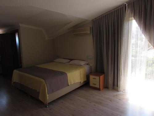 sypialnia z łóżkiem i oknem w obiekcie Dogan Apart Hotel w mieście Göcek