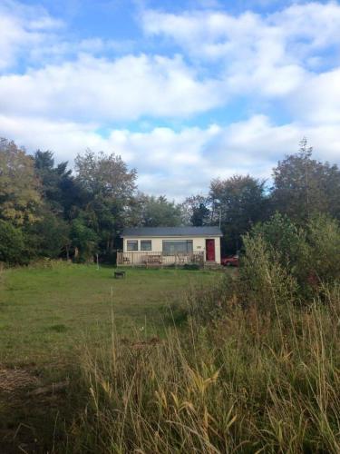 a small house in the middle of a field at Erinona Chalet in Kesh
