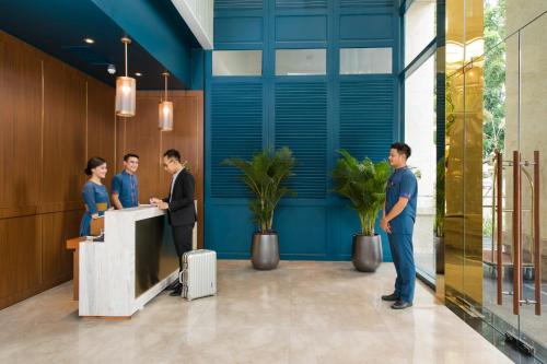 a group of people standing at a reception desk at Lavis 18 Residence in Ho Chi Minh City