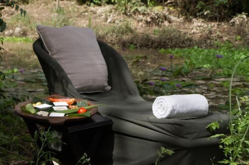 a chair with a towel and a plate of food at Jim's Jungle Retreat in Rāmnagar